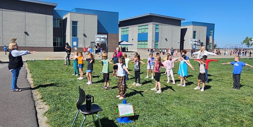 Rock Creek students at an activity outside for Vertical teaming day. holding their arms out.