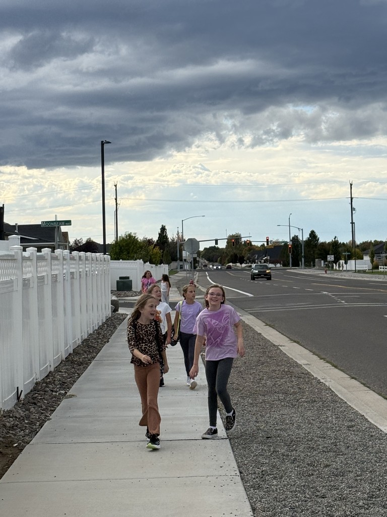 girls walking on a path with a teacher