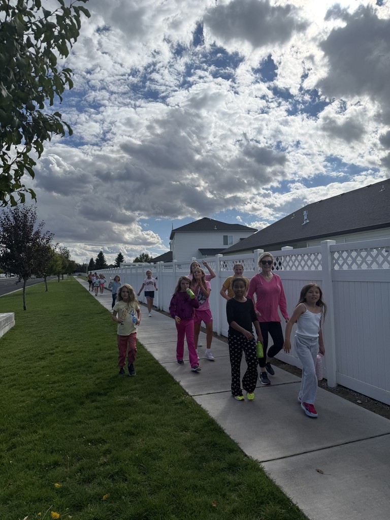 girls walking on a path with a teacher
