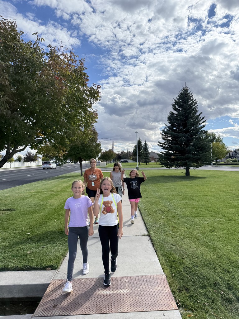 girls walking on a path with a teacher