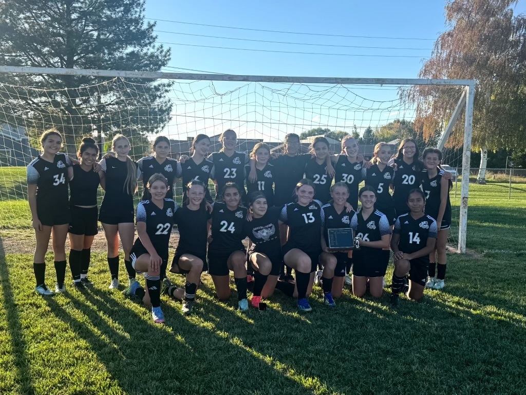 A picture of our girls soccer team on the field.