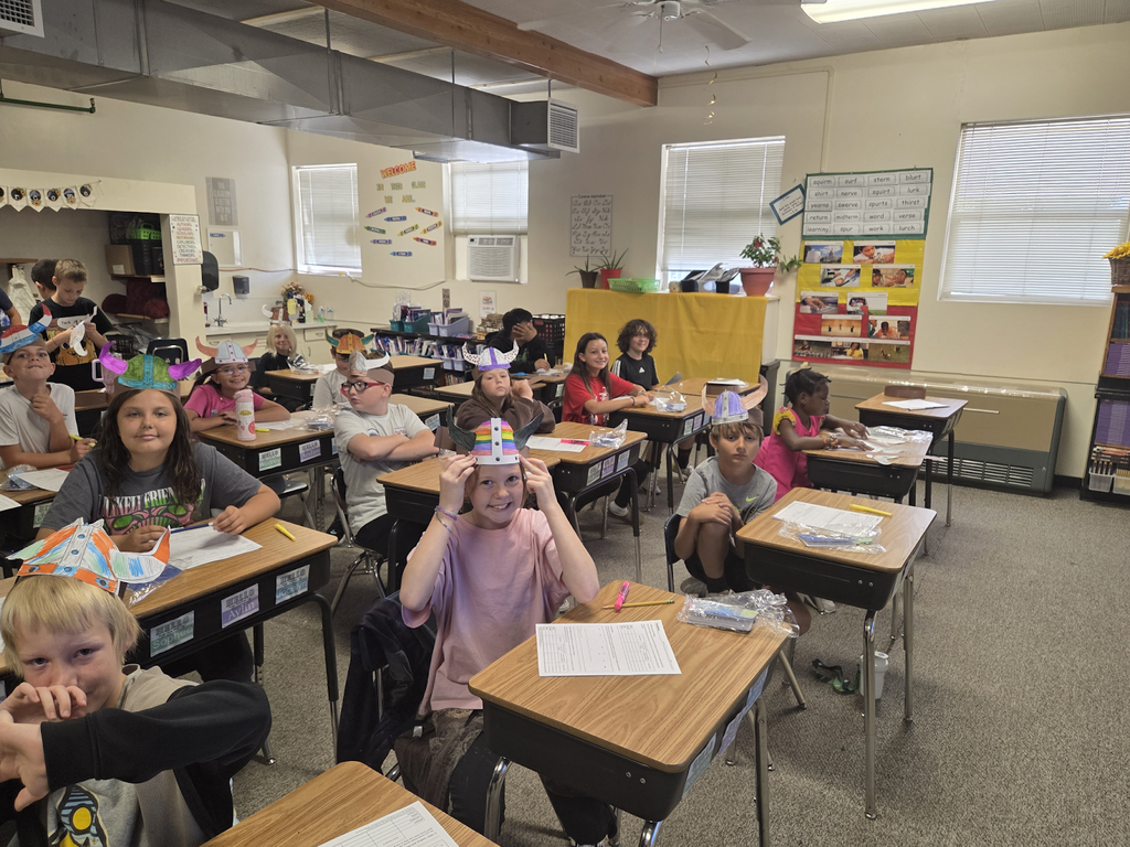 Morningside students at their desks showing off their Viking hats they created.