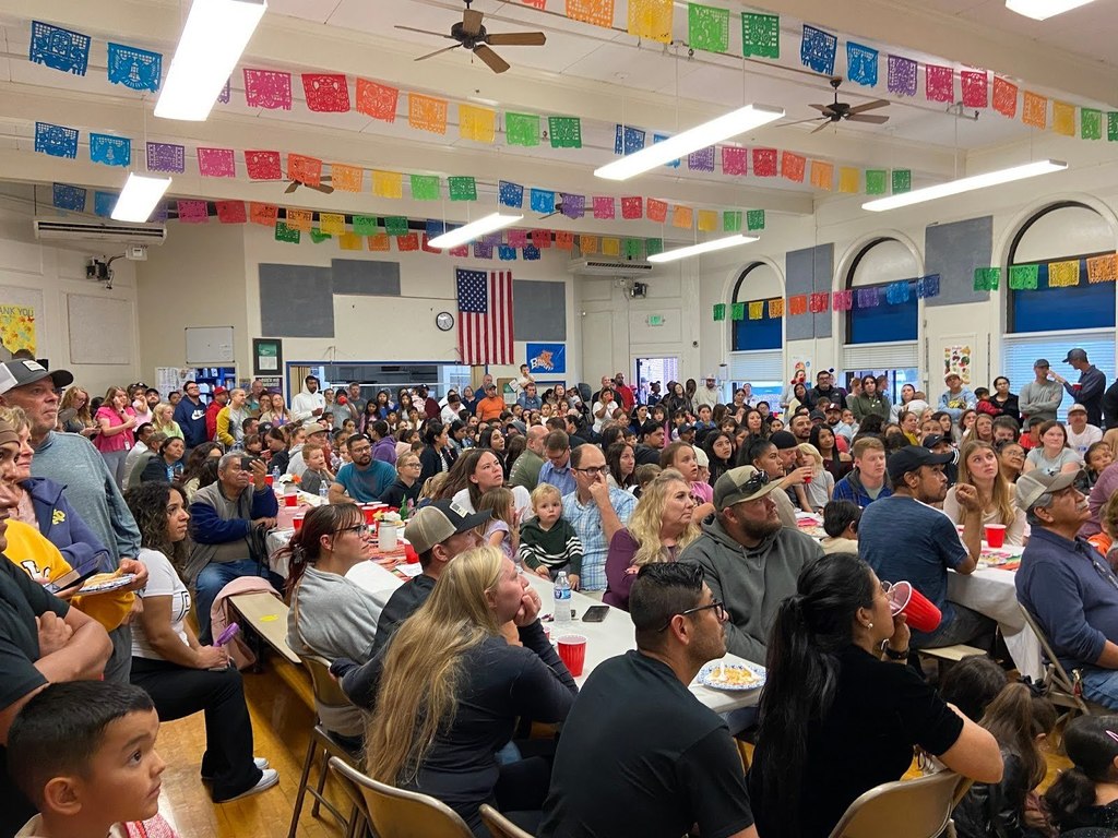 Families and guests sitting in the Bickel Cafetria enjoying dinner and a program of traditional dances from Mexico and Columbia preformed by Bickel and Harrison Elementary students.