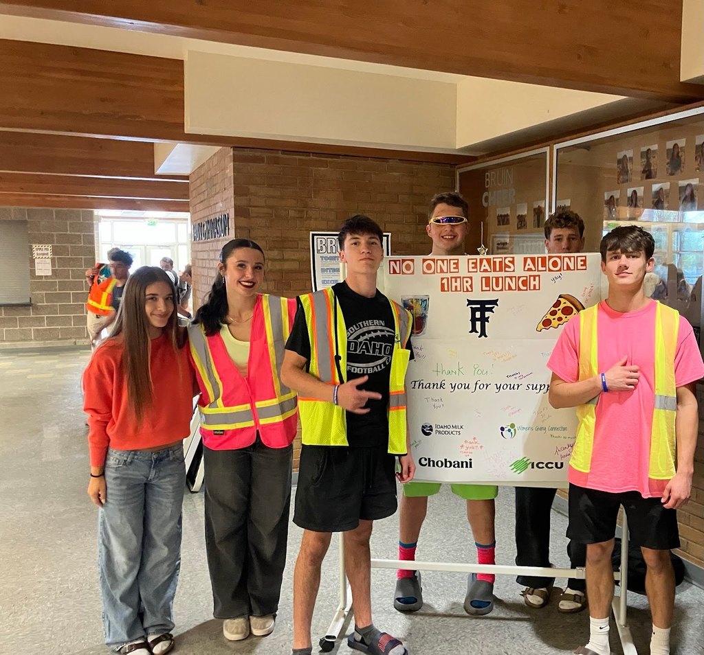 No one eats alone at Twin Falls High school committee holding a sponsor sign.