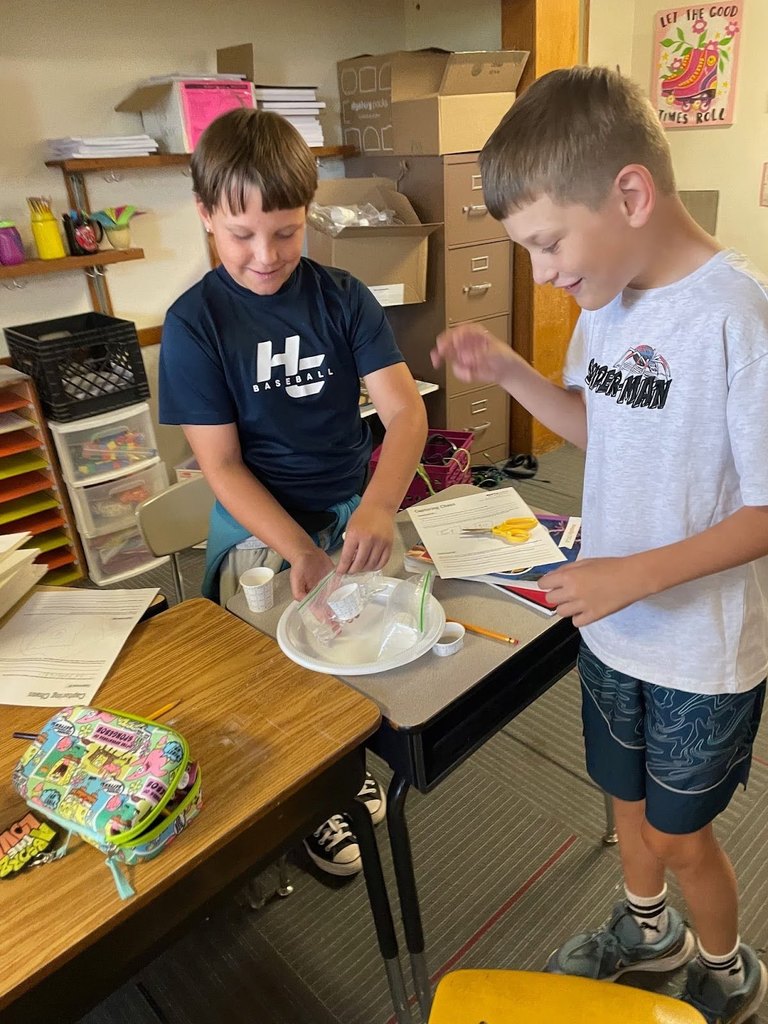 Harrison 5th graders mixing baking soda and vinegar to study gas pressure and chemical reactions.