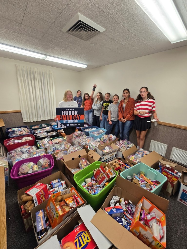 students standing with 27 totes of food organized by the Church of Jesus Christ of Latter-Day Saints in honor of 9/11