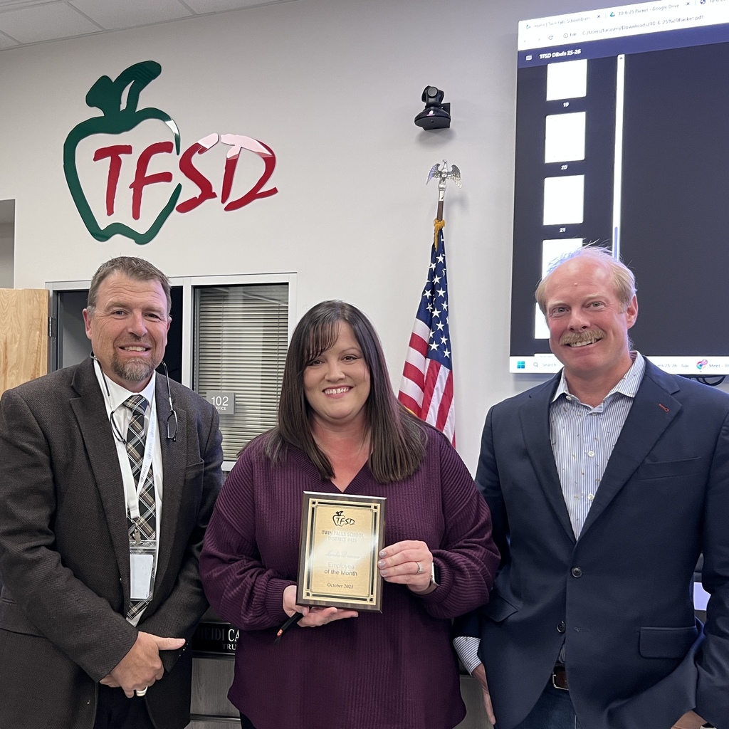 Mandy Brennan holding her Employee of the Month Plaque with Board Member Eric Smallwood and Dr. Dickinson