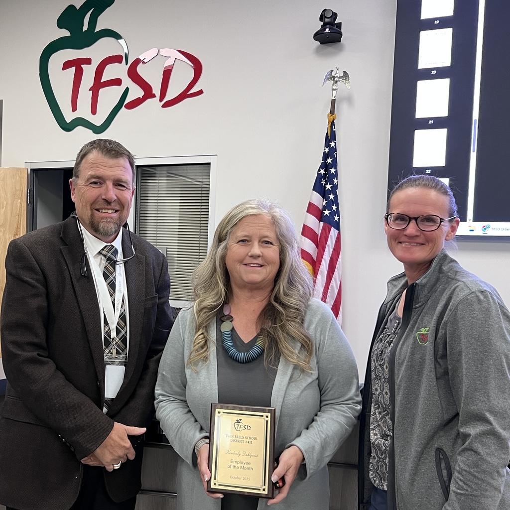 Kim Dahlquist holding her Employee of the Month plaque with Board Member Heidi and Dr. Dickinson.