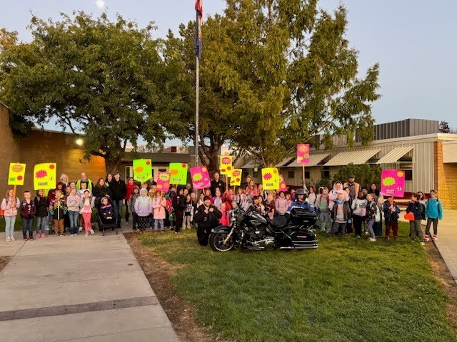 Morningside students on National Walk to School Day with saftey signs and police officers teaching them about safety.