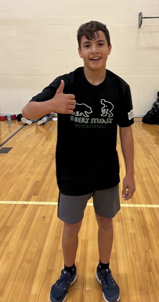a picture of a student in a gym wearing gray shorts and a black tshirt with his thumb up