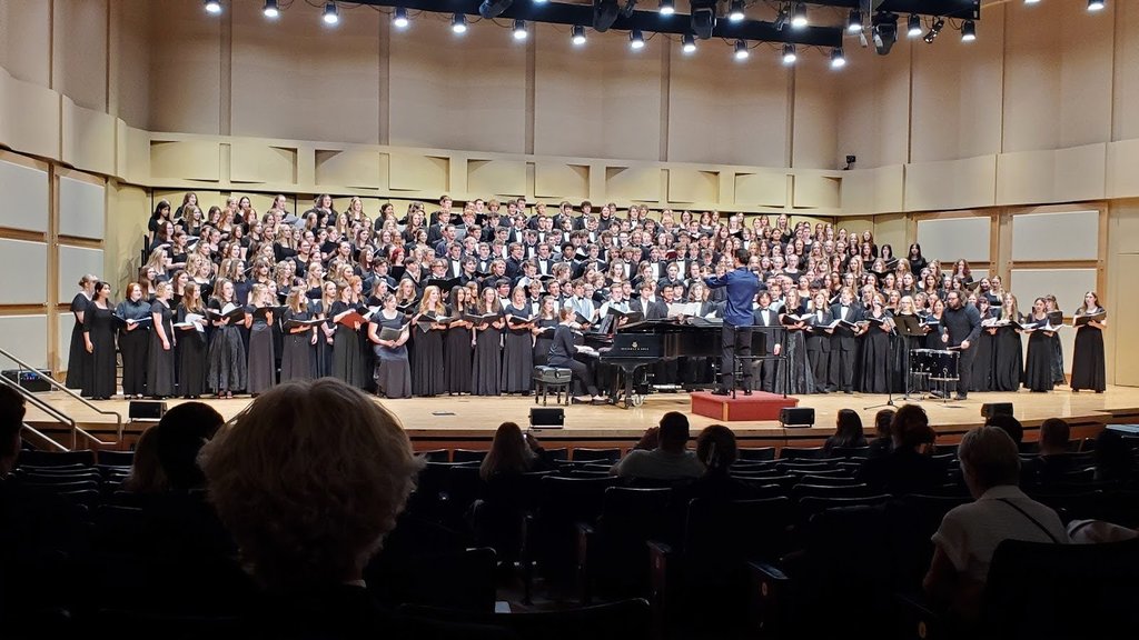 Twin Falls and Canyon ridge choirs on stage at the iSU Choral invitational singing with a world renowned composer Jake Rudestad.