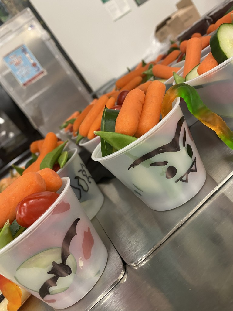 a picture of clear plastic cups filled with vegetables and Halloween symbols on the cup