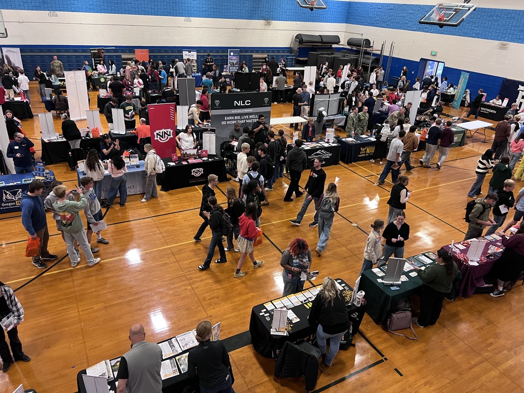 Students and college and career booths in a gym.