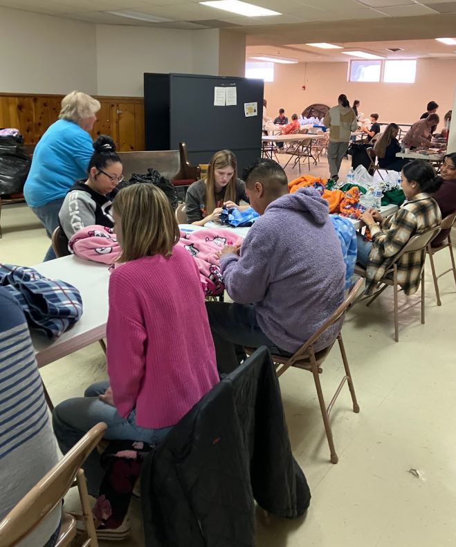 Students at tables working on quilts.