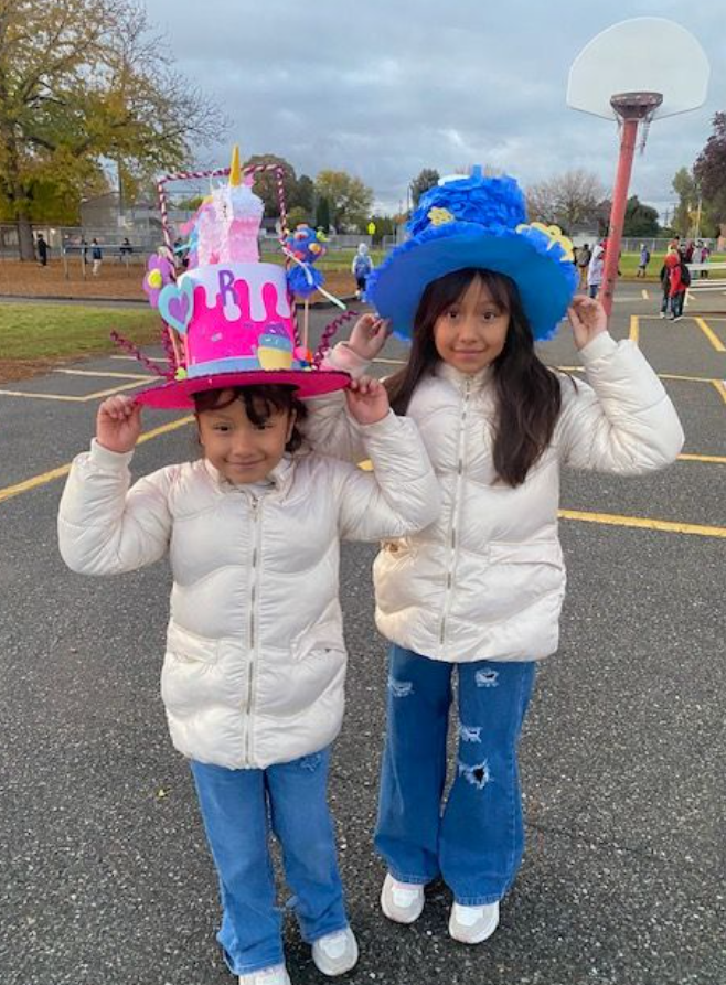 two students wear elaborate hats on the playground