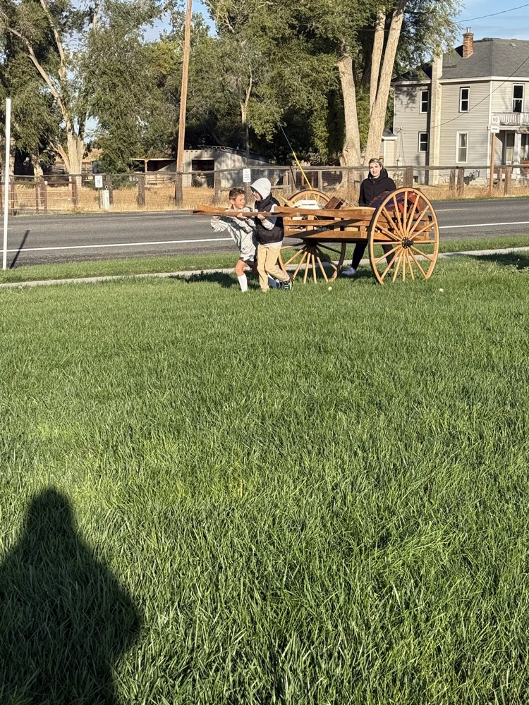 students outside, pulling a cart