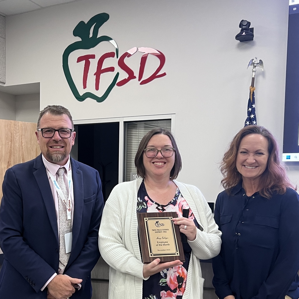 Mary Gallegos receives a plaque from Dr. Dickinson and a School Board trustee.