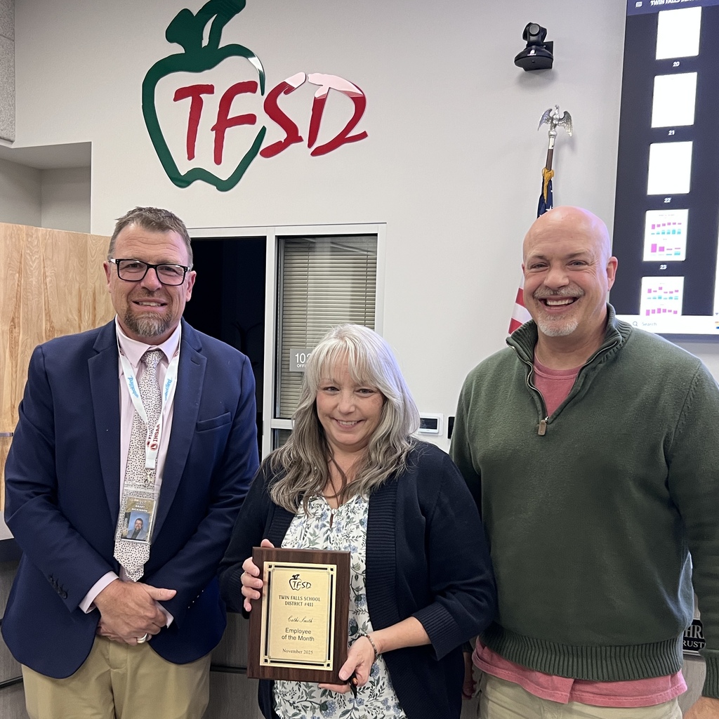 Cathi Smith receives a plaque from Dr. Dickinson and a School Board trustee.
