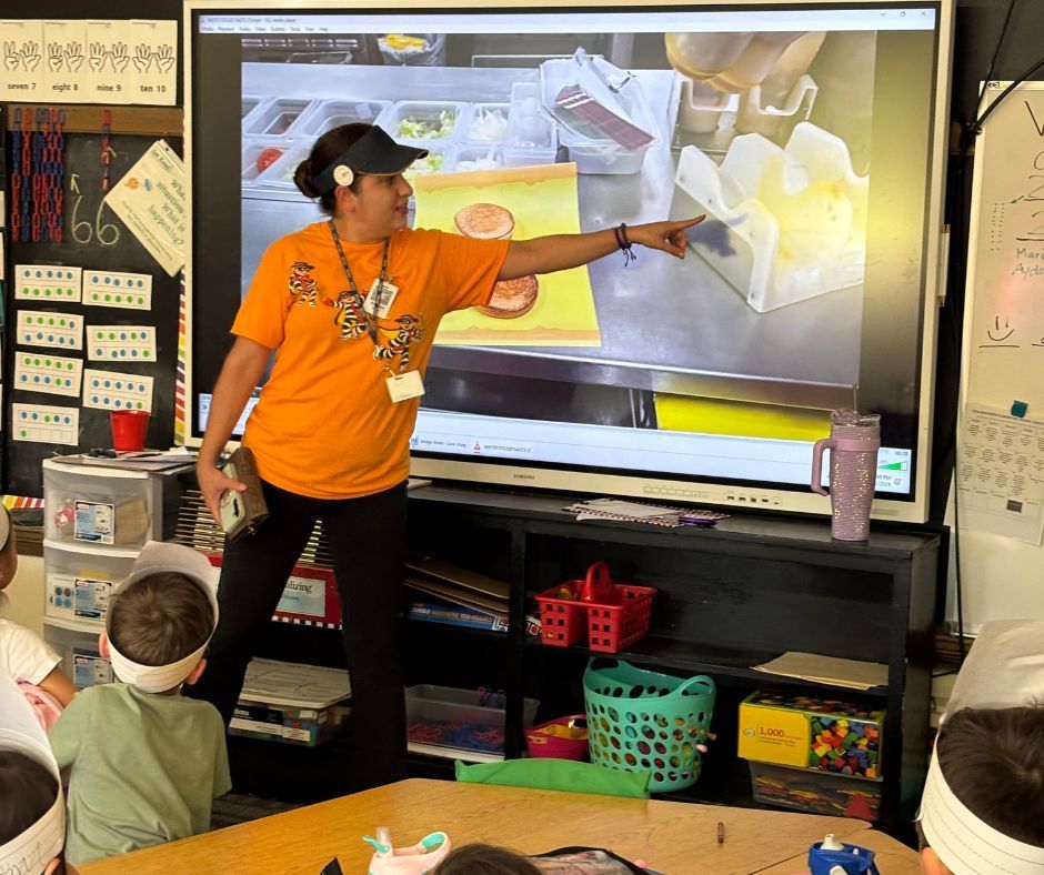 Resturaunt worker teaching kids about how they make the food