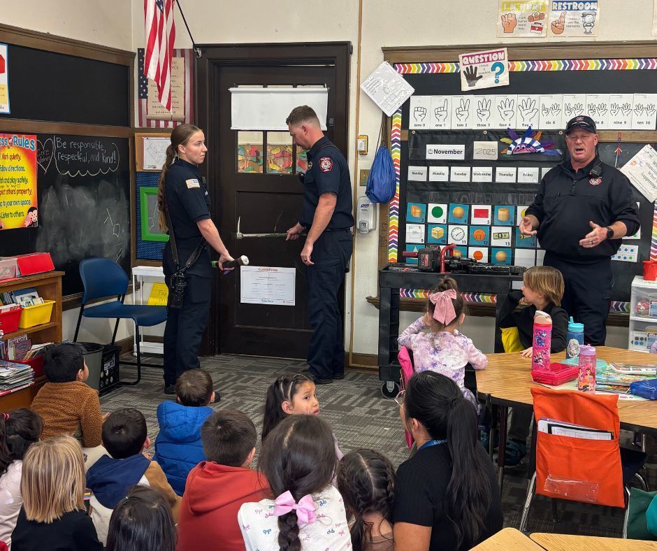 Firefighters demonstrating to a class of kids