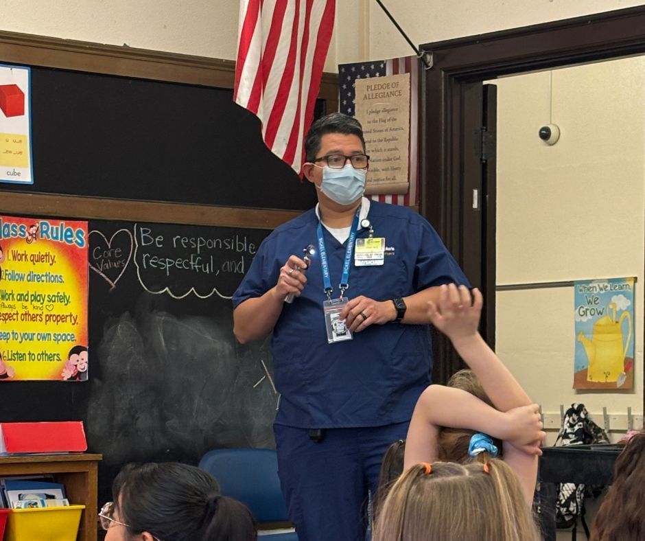 man in scrubs and mask teaching students about his job