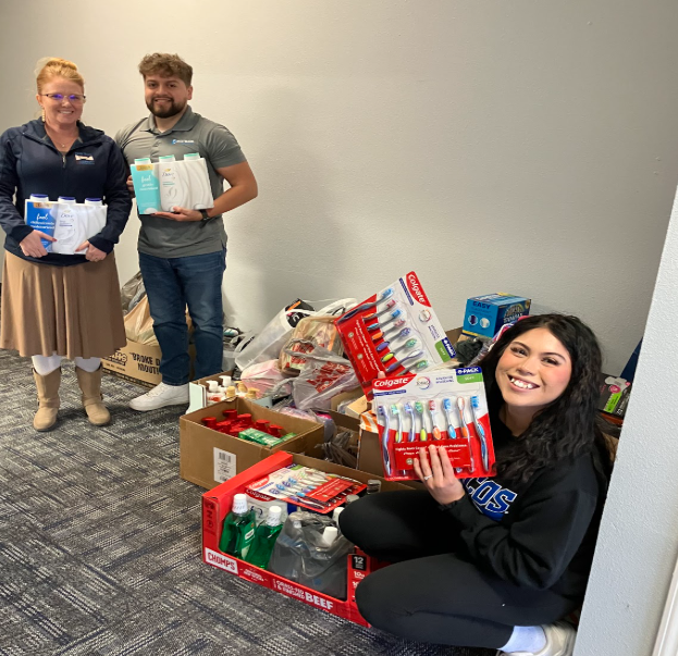 Young professionals drop off hygiene supplies