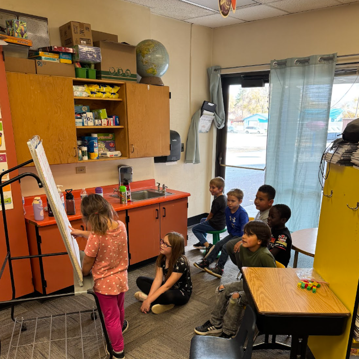 One student leads a small group of students in a reading exersize