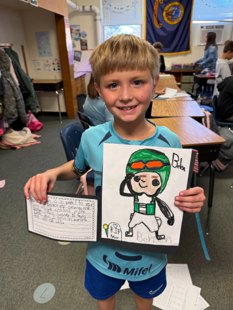 A student shows his artwork and project for Veterans Day