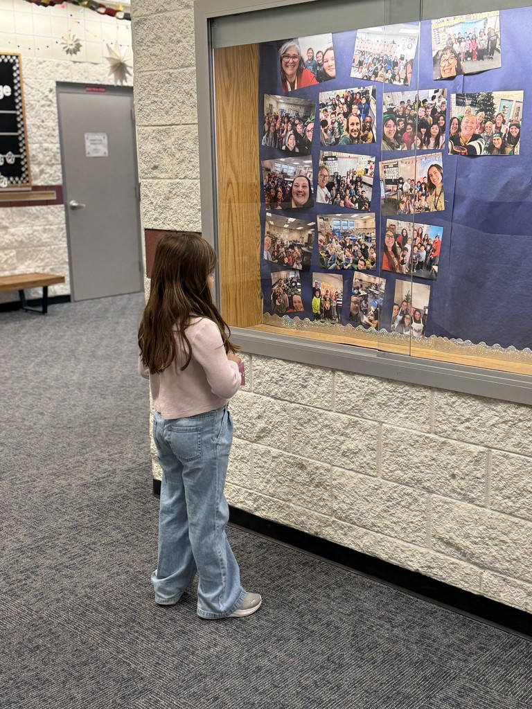 Student admiring pictures in the hallway