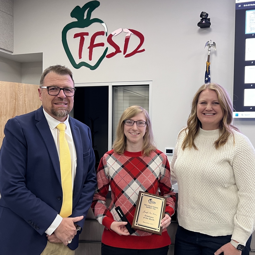 Employee of month standing with the superintendent and school board trustee.