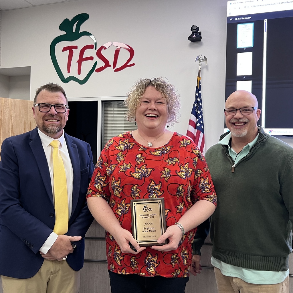 Employee of month standing with the superintendent and school board trustee.