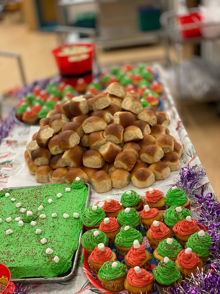 A picture of a pile of rolls and green and red cupcakes 