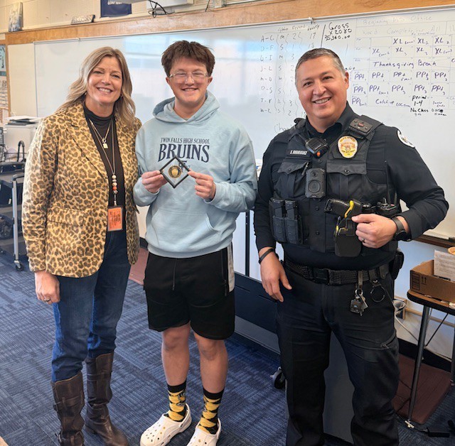 SRO, Male Student, and Principal standing with Challenge Coin