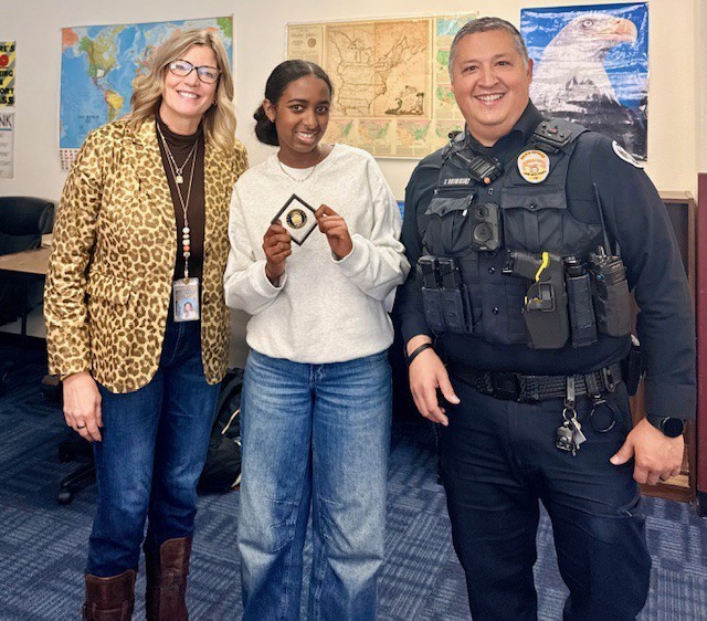 SRO,  Female Student, and Principal standing with Challenge Coin