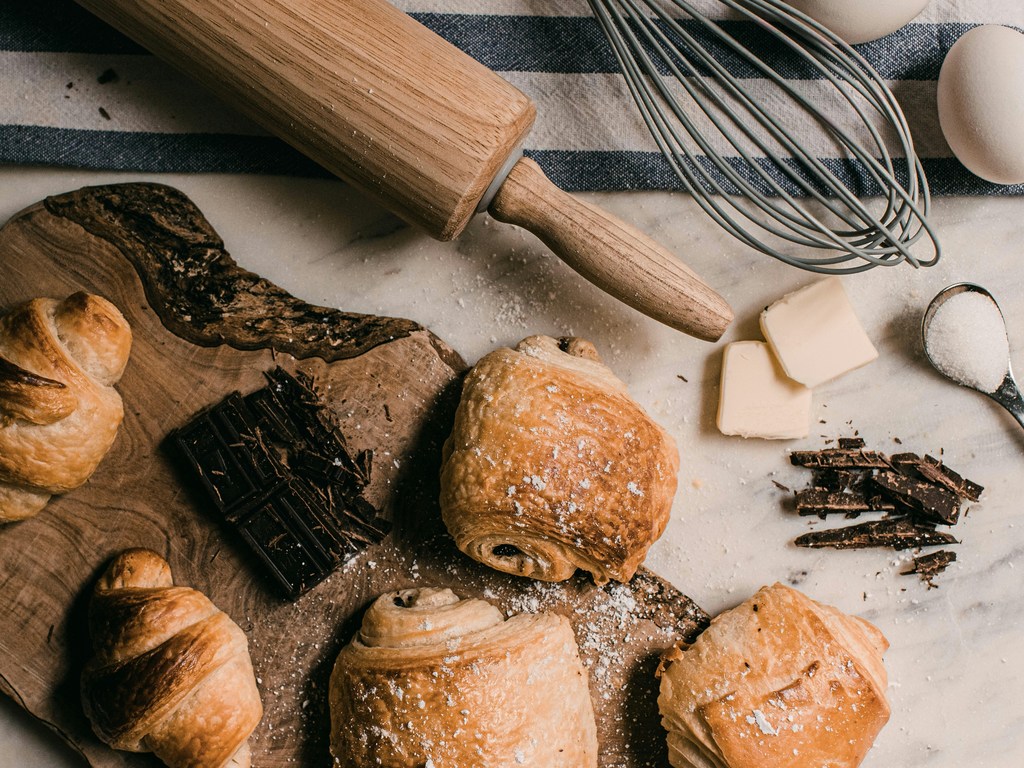 rolling pin, whisk, butter, and baked goodies spread out on a table.  Yummy!