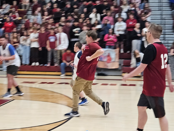 Students running across basketball court