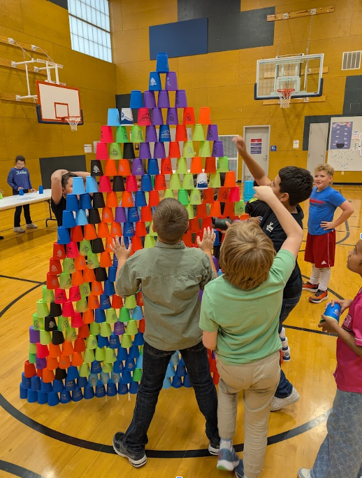 Students stacking cups in a pyramid. 