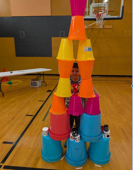 Child smiling through a stack of buckets