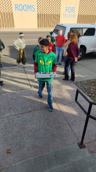 Student carrying a box of canned goods