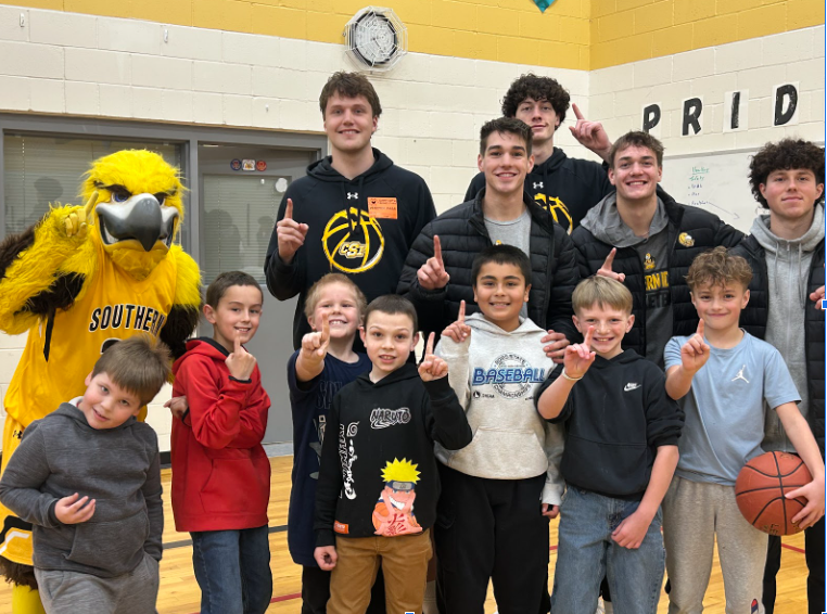 Group of students smiling with CSI students and mascot in gym