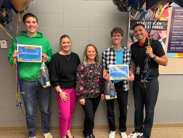 3 teachers and 2 students pose for photo with balloons and certificates.
