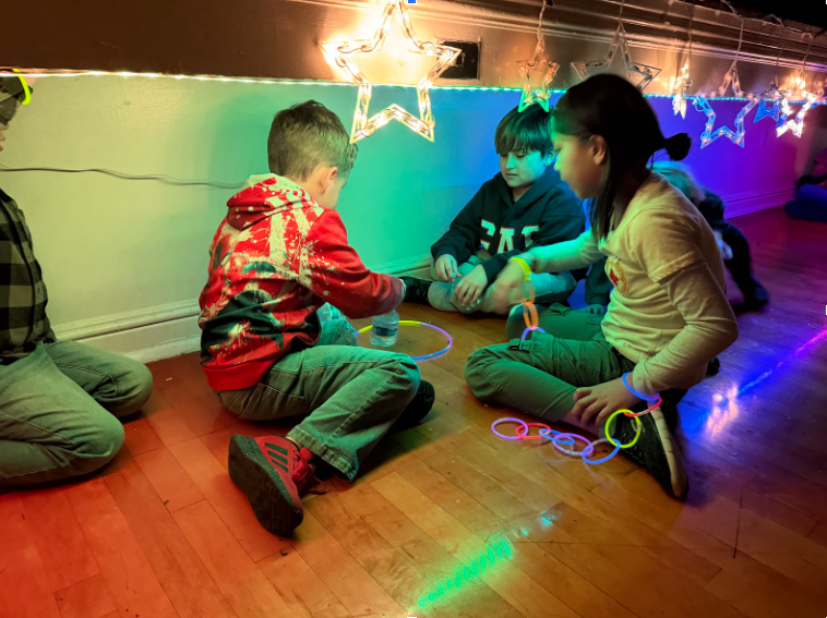 Kids playing on gym floor with adorable star lighted strands adorned in glow bracelets