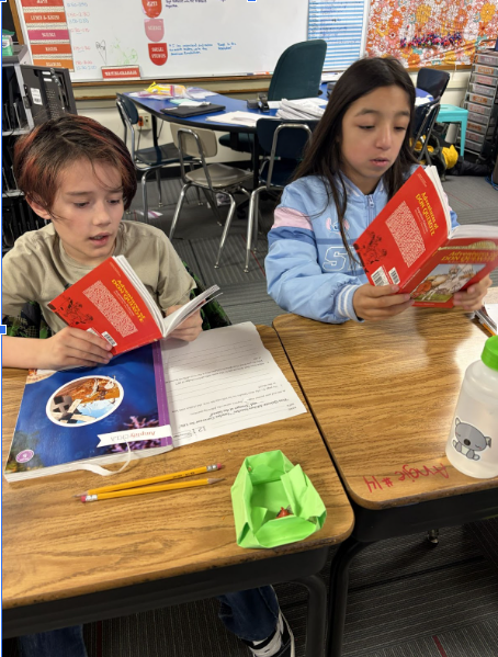 Two students hard at work, reading at their desks, one step closer to becoming knights.