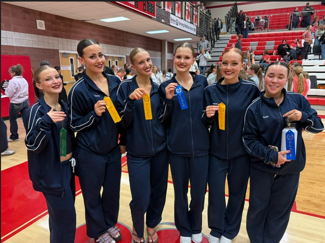 6 dancers stand in warmups showing off the ribbons they won
