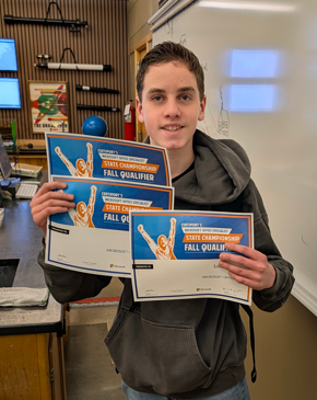 Male student holding 3 different Microsoft certifications
