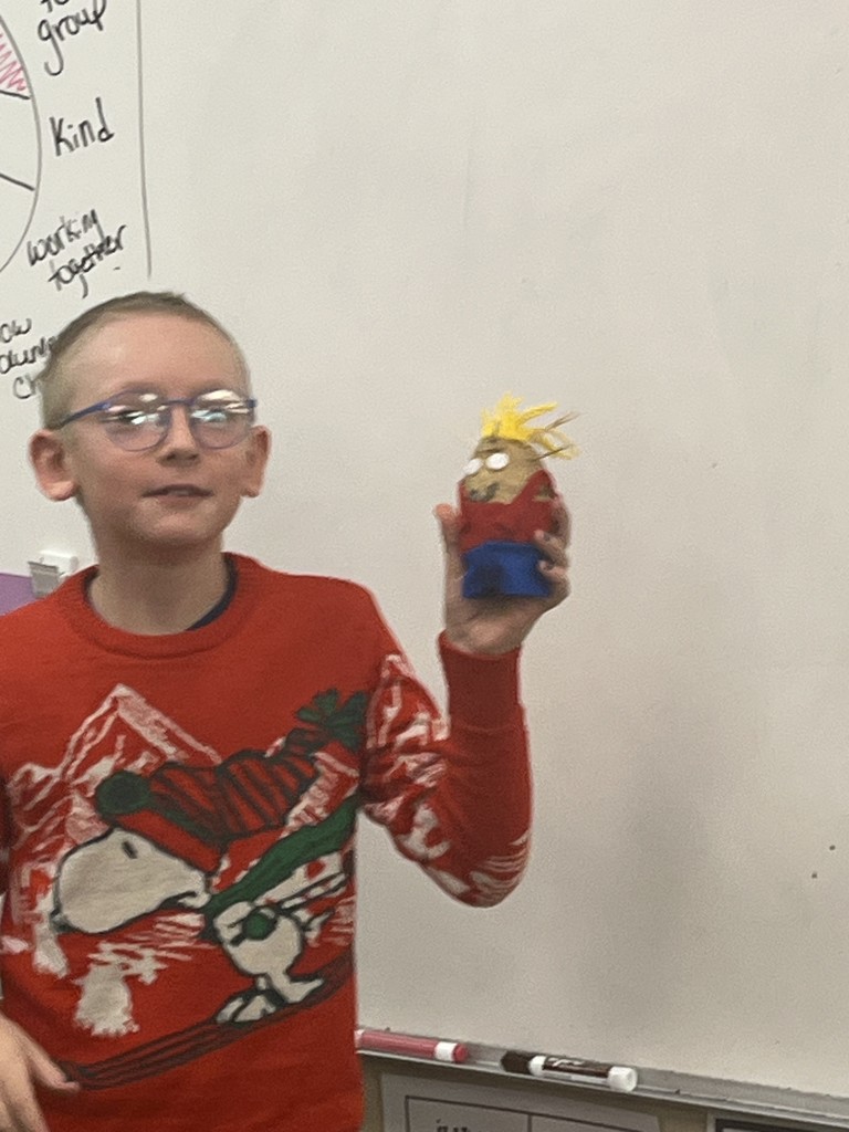 Student showing a decorated potato