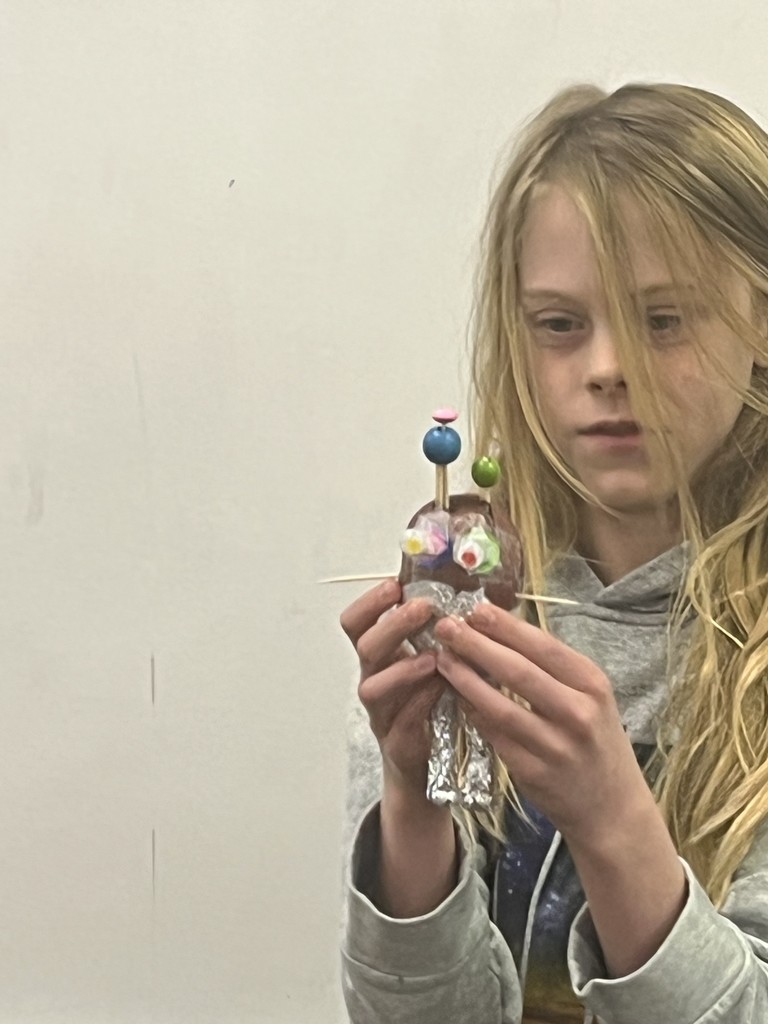 Student showing a decorated potato