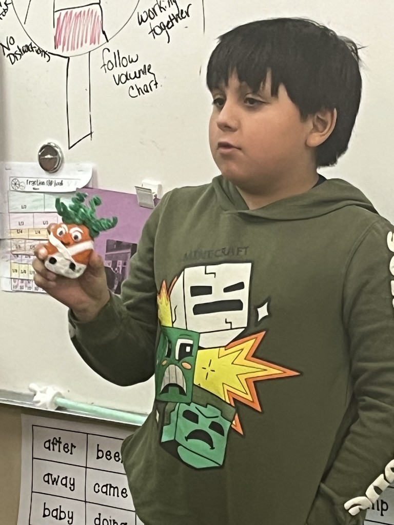 Student showing a decorated potato
