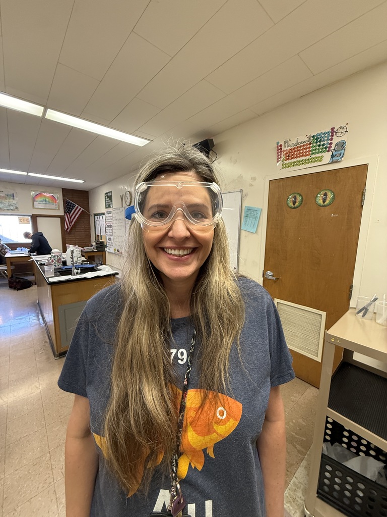 a female teacher wearing googles in her science room
