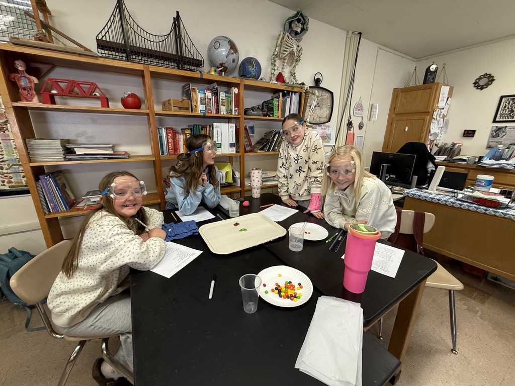 a group of four female students conducting a science experiment